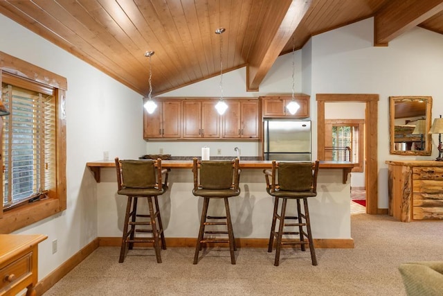 kitchen featuring lofted ceiling with beams, light colored carpet, stainless steel fridge, and baseboards