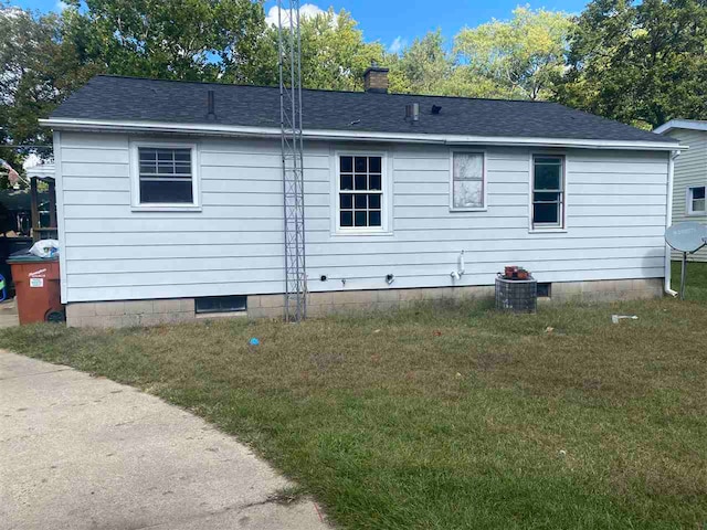 rear view of property featuring a lawn