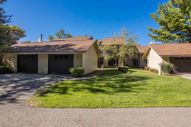 ranch-style home featuring a front yard and a garage