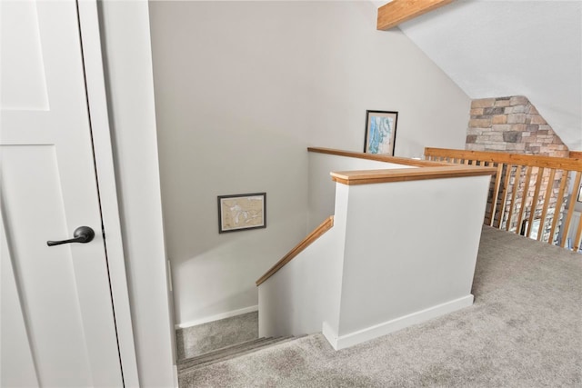 staircase with vaulted ceiling with beams and carpet