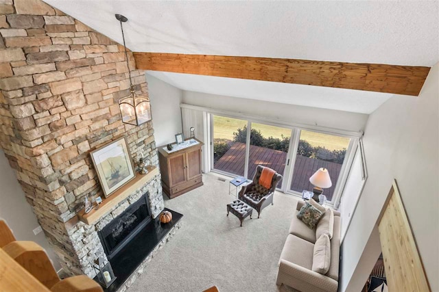 carpeted living room featuring lofted ceiling, a textured ceiling, and a fireplace