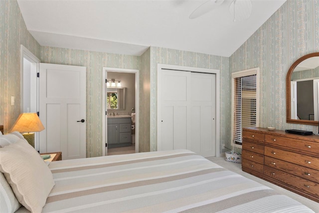 bedroom featuring a closet, lofted ceiling, ceiling fan, and ensuite bathroom