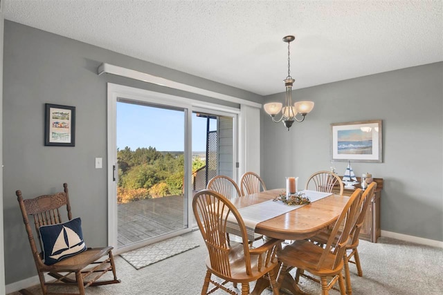 dining space with a notable chandelier, a textured ceiling, and carpet flooring