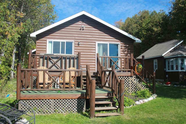 rear view of property featuring a deck and a lawn