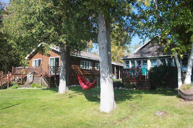 back of house featuring a lawn and a wooden deck