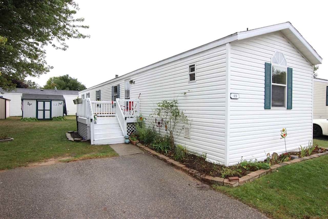 exterior space with a lawn and a storage shed