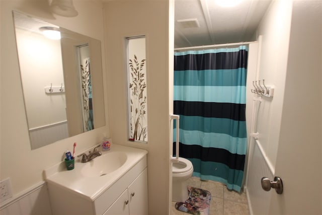 bathroom with tile patterned flooring, curtained shower, vanity, and toilet