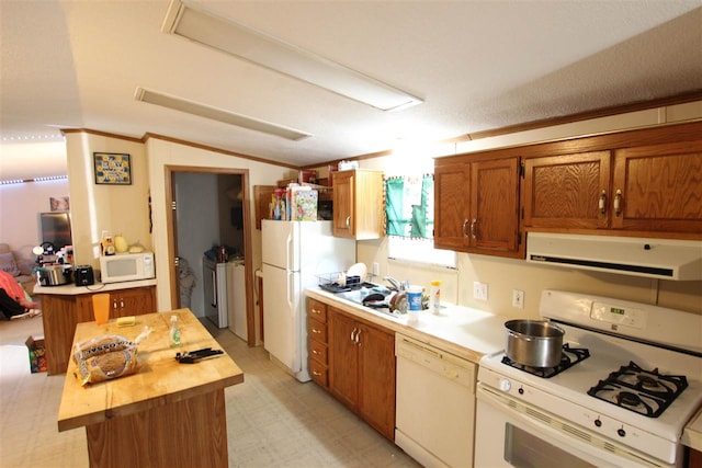 kitchen featuring a textured ceiling, a center island, ventilation hood, white appliances, and washer and clothes dryer