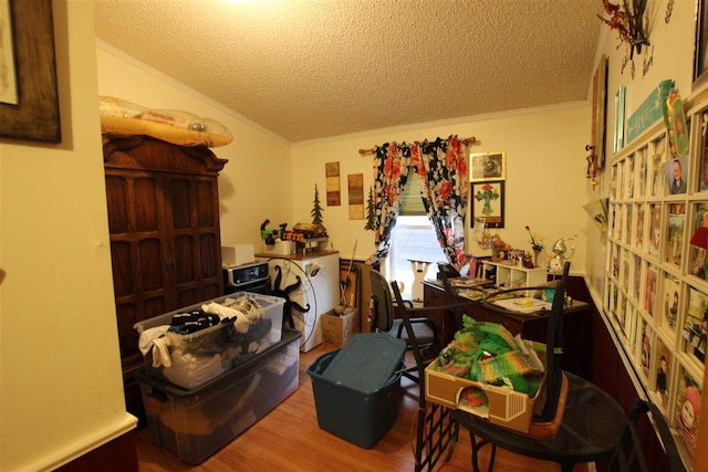 misc room with ornamental molding, light wood-type flooring, lofted ceiling, and a textured ceiling