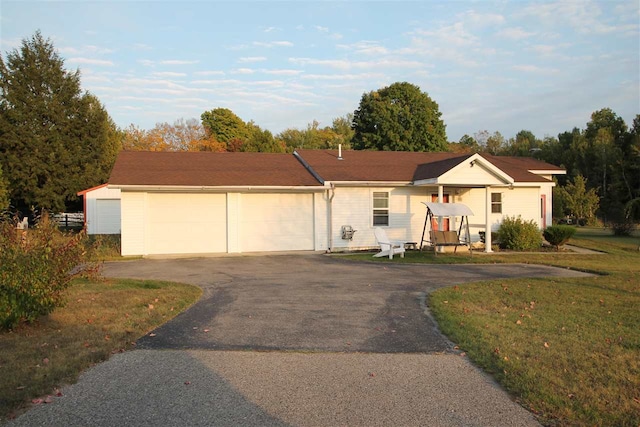 ranch-style home featuring a garage and a front yard