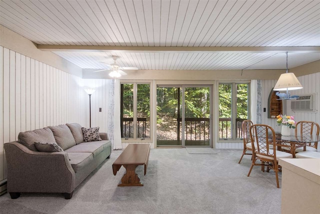 living room with beamed ceiling, wood walls, light carpet, and ceiling fan