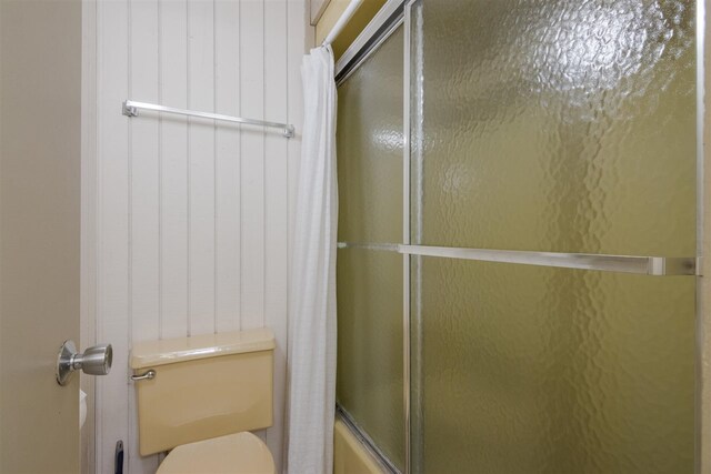 2500 Josef Strasse Unit 410/411, Bellaire, MI 49615 - bathroom featuring toilet and bath / shower combo with glass door