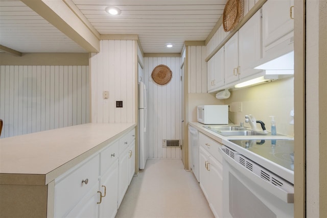 kitchen featuring wood ceiling, wood walls, sink, white appliances, and white cabinetry