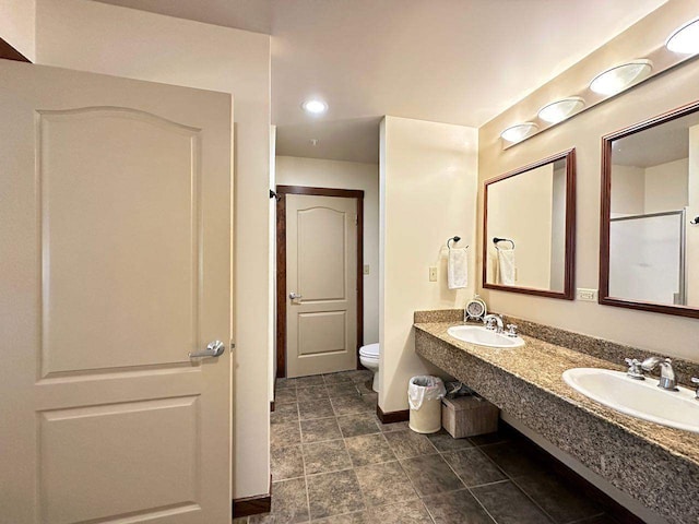 bathroom featuring vanity, a shower with shower door, and toilet