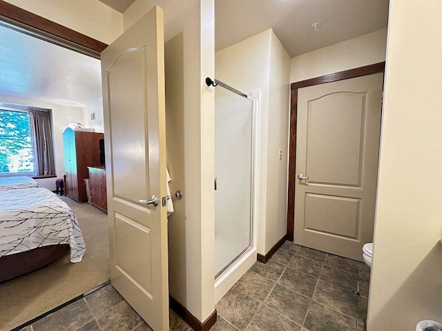 bathroom with a shower with shower door and toilet