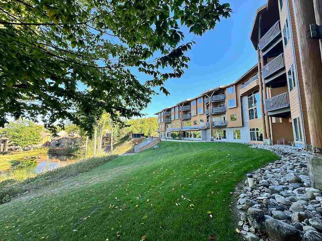 view of yard with a balcony and a water view