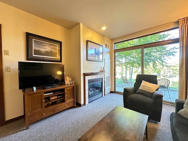 carpeted living room featuring a tile fireplace