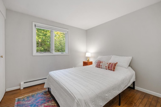 bedroom with hardwood / wood-style floors and baseboard heating