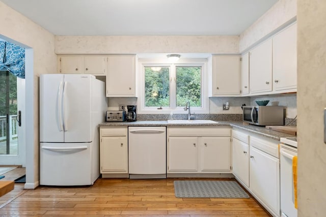 kitchen featuring appliances with stainless steel finishes, white cabinetry, sink, and light hardwood / wood-style flooring