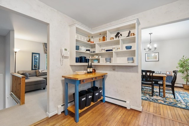 kitchen with wood counters, hanging light fixtures, light hardwood / wood-style flooring, and a baseboard radiator