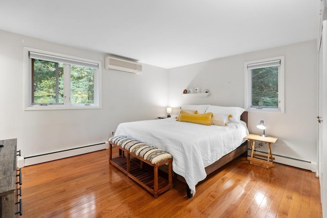 bedroom with baseboard heating, hardwood / wood-style flooring, and a wall unit AC