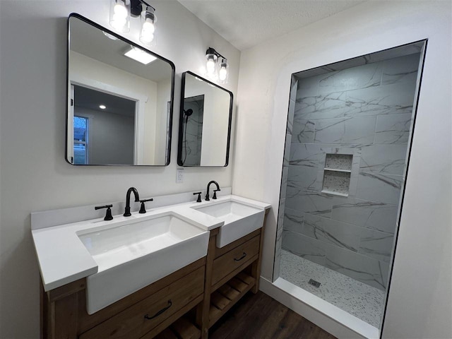 bathroom with a tile shower, vanity, a textured ceiling, and hardwood / wood-style flooring