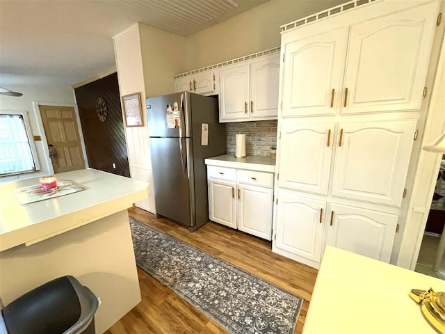 kitchen featuring backsplash, stainless steel refrigerator, white cabinets, and dark hardwood / wood-style floors