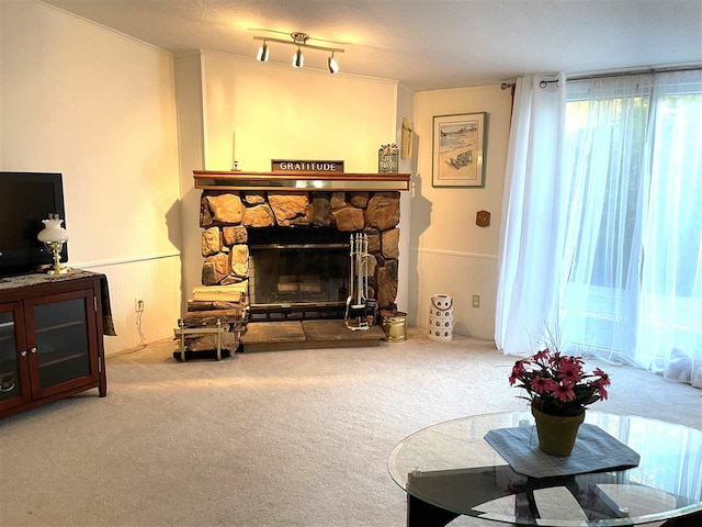 living room featuring crown molding, a fireplace, carpet floors, and a textured ceiling