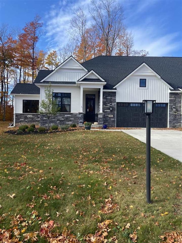 modern farmhouse style home featuring a front yard and a garage