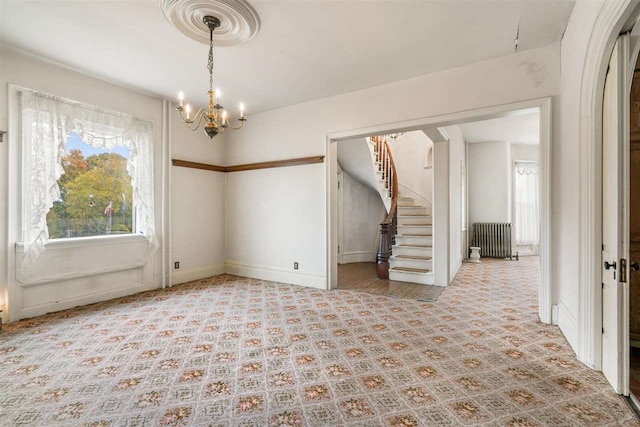 unfurnished room featuring a notable chandelier and radiator heating unit