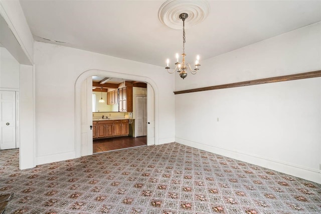 empty room featuring sink and an inviting chandelier