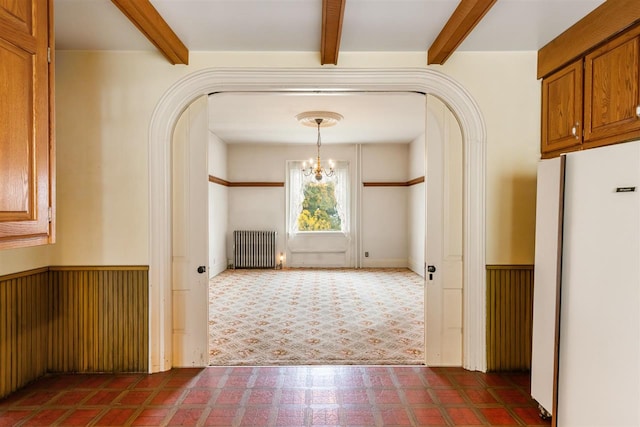 corridor with a chandelier, beam ceiling, and radiator heating unit