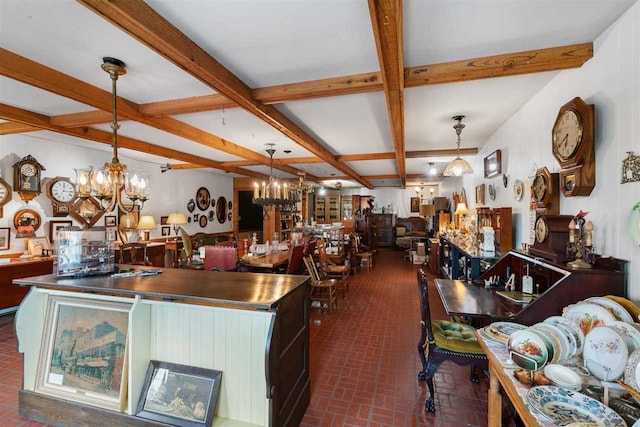 kitchen with stainless steel counters, hanging light fixtures, and beam ceiling