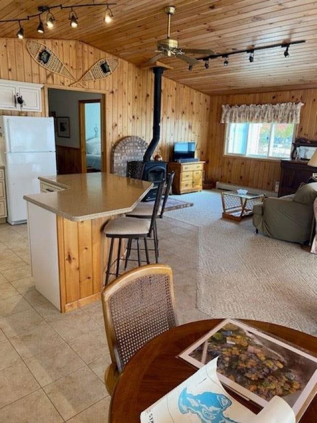 kitchen featuring wooden walls, wooden ceiling, lofted ceiling, and white refrigerator