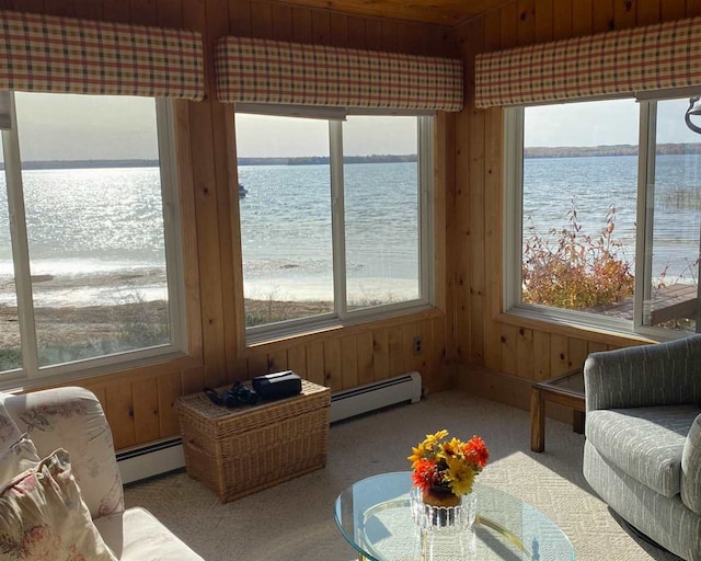 sunroom / solarium with baseboard heating and a water view