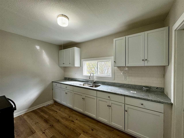 kitchen featuring tasteful backsplash, sink, dark hardwood / wood-style floors, and white cabinets