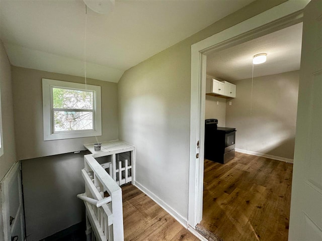 staircase featuring lofted ceiling and hardwood / wood-style floors