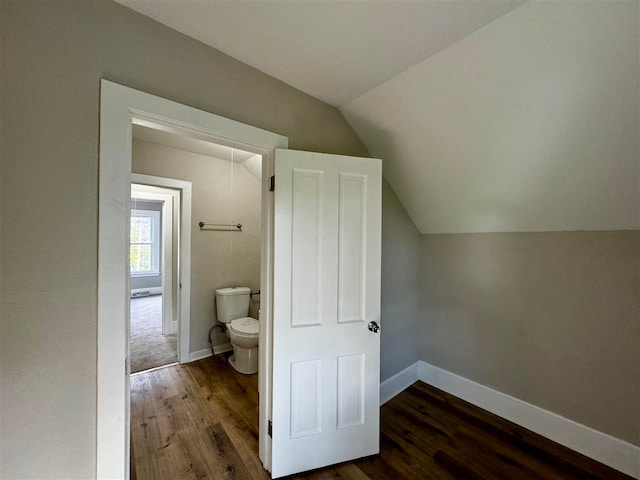 bathroom featuring lofted ceiling, hardwood / wood-style flooring, and toilet