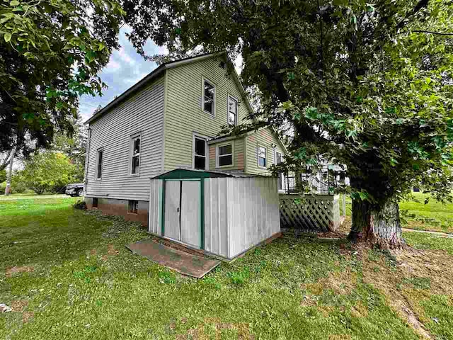 view of side of home with a lawn and a shed