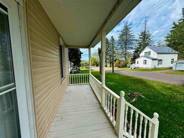 deck featuring a yard and covered porch