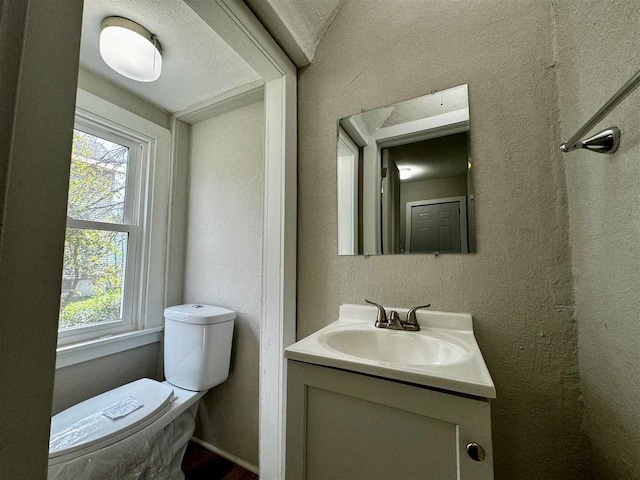 bathroom featuring vanity, toilet, and a textured ceiling