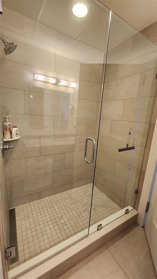 bathroom featuring walk in shower and tile patterned flooring