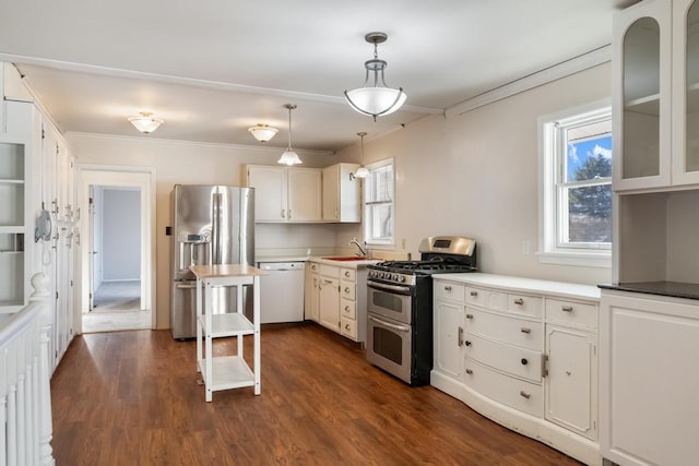 kitchen featuring appliances with stainless steel finishes, hanging light fixtures, white cabinetry, and dark hardwood / wood-style flooring