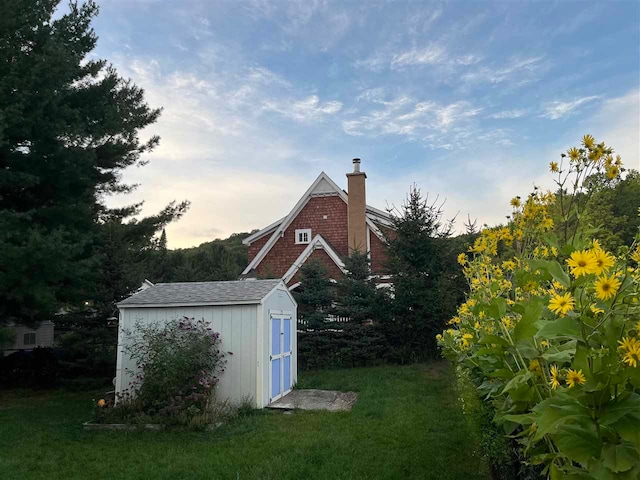 outdoor structure at dusk featuring a lawn