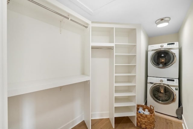 washroom with hardwood / wood-style floors and stacked washer and dryer