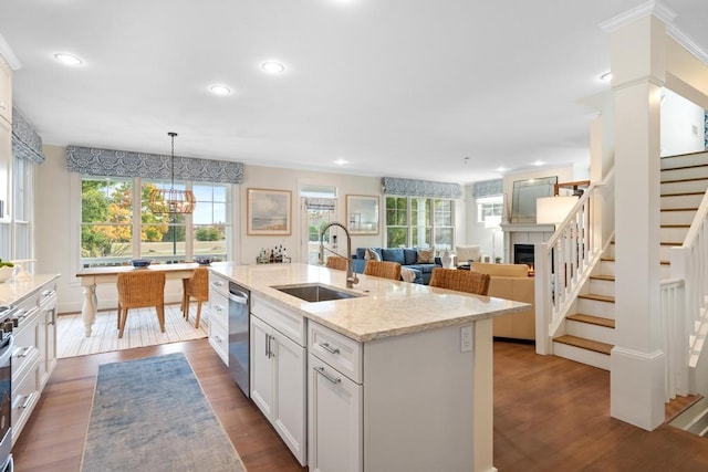 kitchen with sink, dark wood-type flooring, decorative light fixtures, and stainless steel appliances