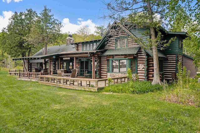 rear view of property featuring a yard and a wooden deck