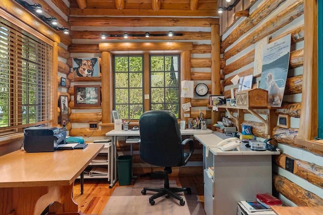 office with light wood-type flooring and rustic walls