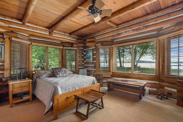 carpeted bedroom with beamed ceiling, ceiling fan, rustic walls, and wooden ceiling