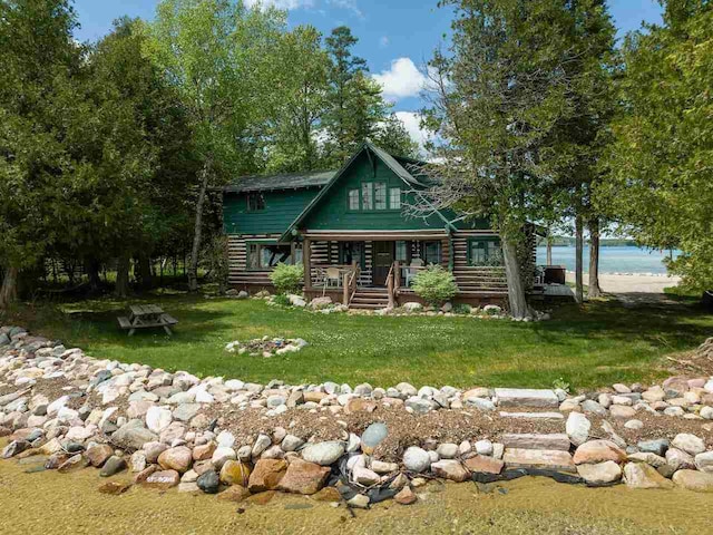 cabin featuring a front yard and a water view